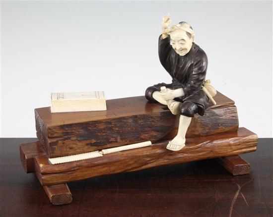 A Japanese ivory, bronze and wood okimono of a carpenter, early 20th century, 32.5cm., some losses